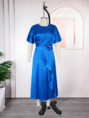 A royal blue midi dress with short sleeves, a draped bodice, and a floral accent at the waist.