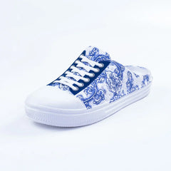 A blue and white floral print slip-on sneaker with white laces and a round toe.
