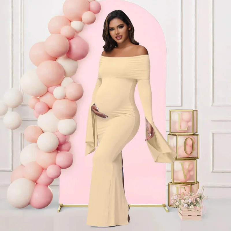A pregnant woman wears a beige off-shoulder long-sleeve mermaid maternity dress.