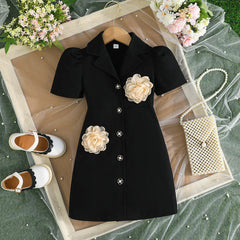 A black short-sleeved blazer dress for girls featuring a turn-down collar and 3D flower appliques.