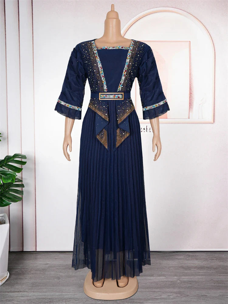 A navy blue pleated maxi dress featuring embellished trim, a belted waist, and three-quarter sleeves.