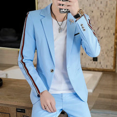 A man wears a light blue slim-fit suit with red and white striped detailing on the sleeves.