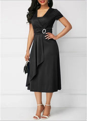 A woman wears a black short-sleeve midi dress with a V-neck, waist buckle, and asymmetric hem.