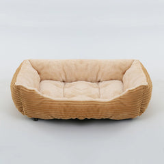 A rectangular pet bed with tan corduroy sides and a soft, plush cream-colored interior.