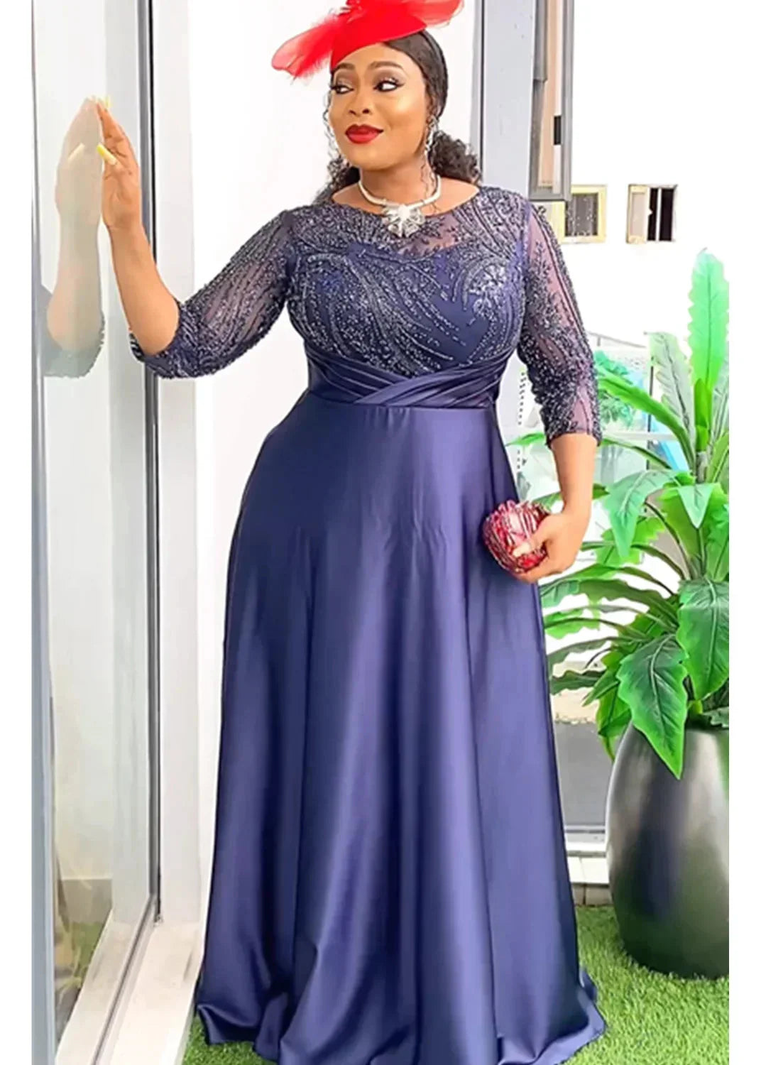 A woman wears a navy blue floor-length gown with a sequined bodice and a satin skirt.
