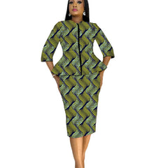 A woman wears a matching two-piece set featuring a peplum blouse and pencil skirt in a wavy green and blue African print.