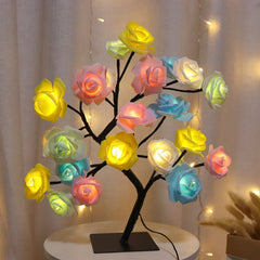 A decorative table lamp shaped like a tree with glowing, multi-colored LED rose flowers.