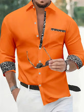 A bright orange long-sleeved button-down shirt with black and white floral patterned accents.