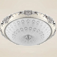 A round, classical-style ceiling light with a decorative silver frame and patterned glass shade.