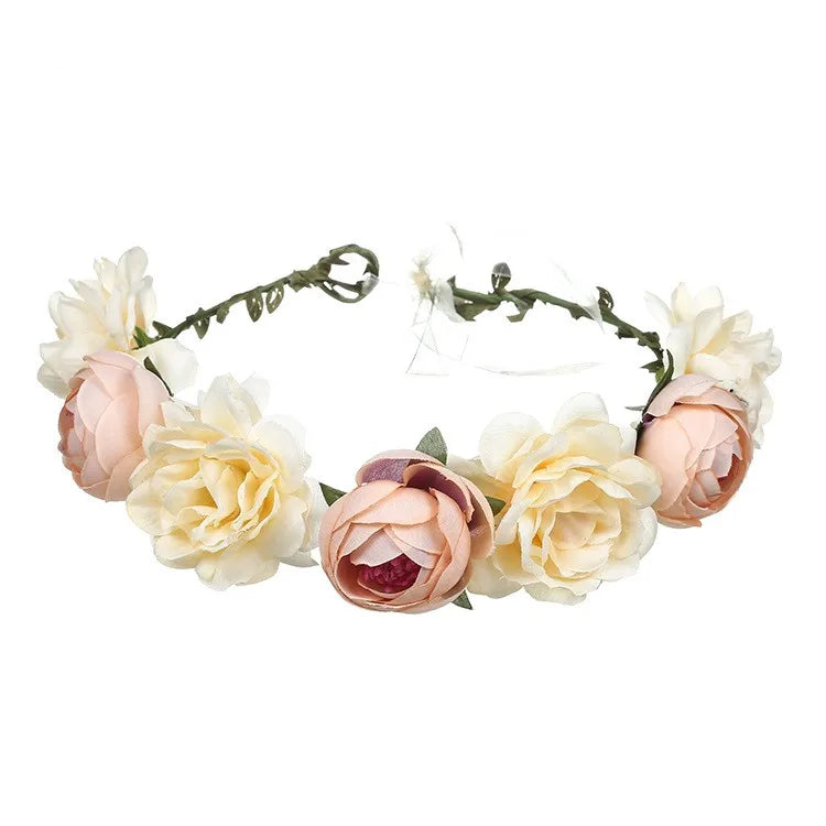 A floral crown featuring artificial cream and dusty pink roses on a thin, adjustable vine band.