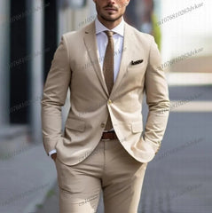 A man wears a two-piece tan business suit with a white shirt and a brown textured tie.