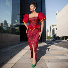 A woman wears a red and black Ankara print ankle-length dress with puff sleeves and a front slit.