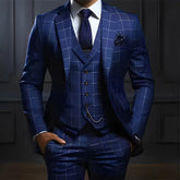 A man wears a blue three-piece suit with a white grid pattern, a white shirt, and a dark tie.