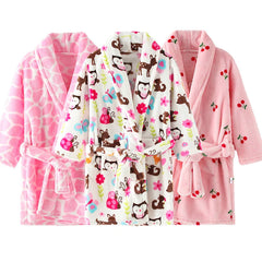 Three children's flannel bathrobes in pink and white with giraffe, animal, and cherry patterns.