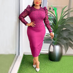 A woman wears a magenta midi-length sheath dress with long lace sleeves and beaded embellishments.