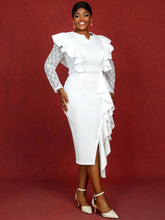 A woman wears a white midi dress with lace sleeves, ruffled details, and a side slit.