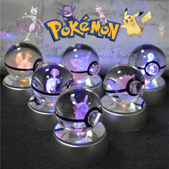 A collection of six glowing glass Pokeball night lights featuring 3D engraved Pokemon figures.