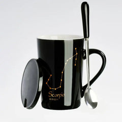 A black ceramic mug featuring a gold Scorpio constellation design, complete with a lid and spoon.