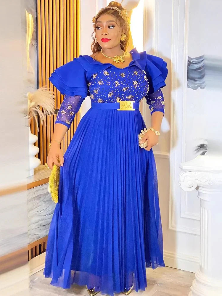 A woman wears a royal blue floor-length A-line gown with butterfly sleeves and crystal embellishments.