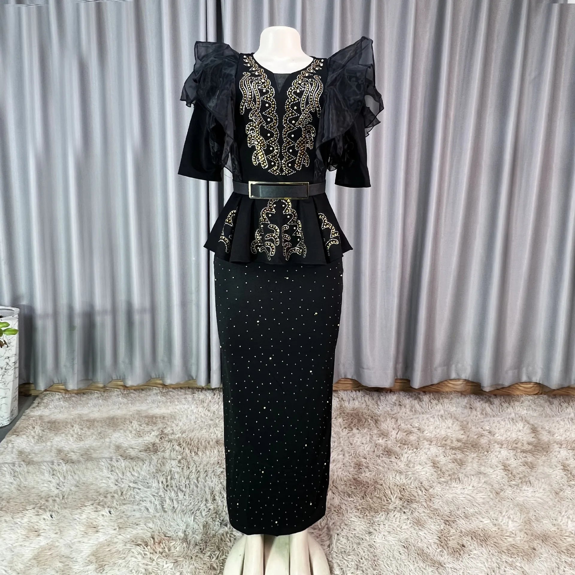 A black African-style bodycon dress with gold embellishments, ruffled sleeves, and a peplum waist.