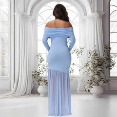 A woman wears a light blue off-shoulder maternity gown with long sleeves and a sheer fishtail hem.