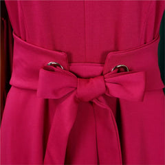 A close-up of a magenta dress featuring a wide waist panel with a decorative bow and silver rings.