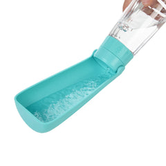 A portable teal plastic pet water bottle with an integrated drinking trough being filled with water.