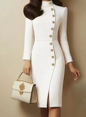 A white knee-length sheath dress with a stand-up collar, side slit, and gold button detailing.