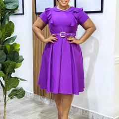 A woman wears a purple short-sleeved midi dress with a ruffled neckline and a buckled belt.