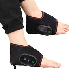 A person wears two black portable electric foot massagers with vibration and heating functions.