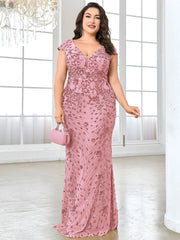 A plus-size woman wears a floor-length, pink sequined mermaid evening gown with a V-neckline.