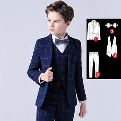 A boy wears a navy blue plaid suit consisting of a blazer, vest, trousers, and a bow tie.