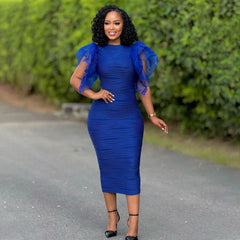 A woman wears a royal blue, mid-calf bodycon dress with a round neckline and ruffled sleeves.