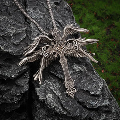 A vintage silver-toned gothic cross pendant featuring intricate wing details on a chain.