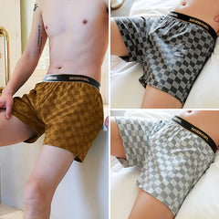 Three pairs of men's cotton plaid boxer shorts with elastic waistbands in different colors.