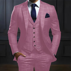 A man wears a pink three-piece plaid suit with a white shirt, dark tie, and pocket square.