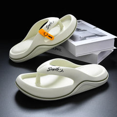 A pair of off-white platform flip-flops with a smile logo and an orange accent tab.