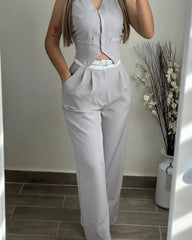 A woman wears a light gray two-piece set featuring a buttoned V-neck vest and high-waisted pants.