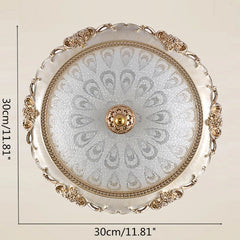 A round, gold-trimmed glass ceiling light with a decorative floral pattern.