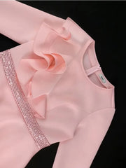 A light pink long-sleeved dress featuring a ruffled bodice and a vertical sequined trim.