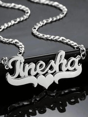 A silver-toned stainless steel nameplate necklace featuring the name Tinesha and a heart symbol.
