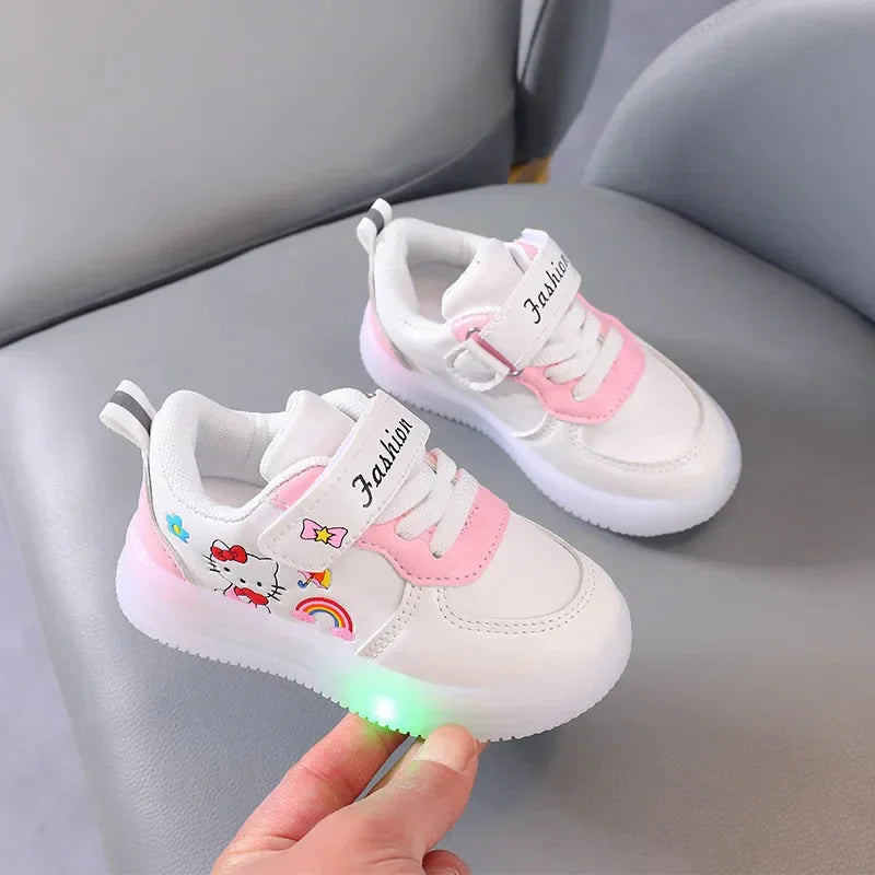 A pair of white and pink Hello Kitty sneakers for girls featuring LED lights and hook-and-loop straps.