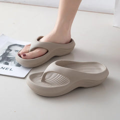 A pair of beige, thick-soled EVA flip-flops with a textured footbed and a minimalist design.
