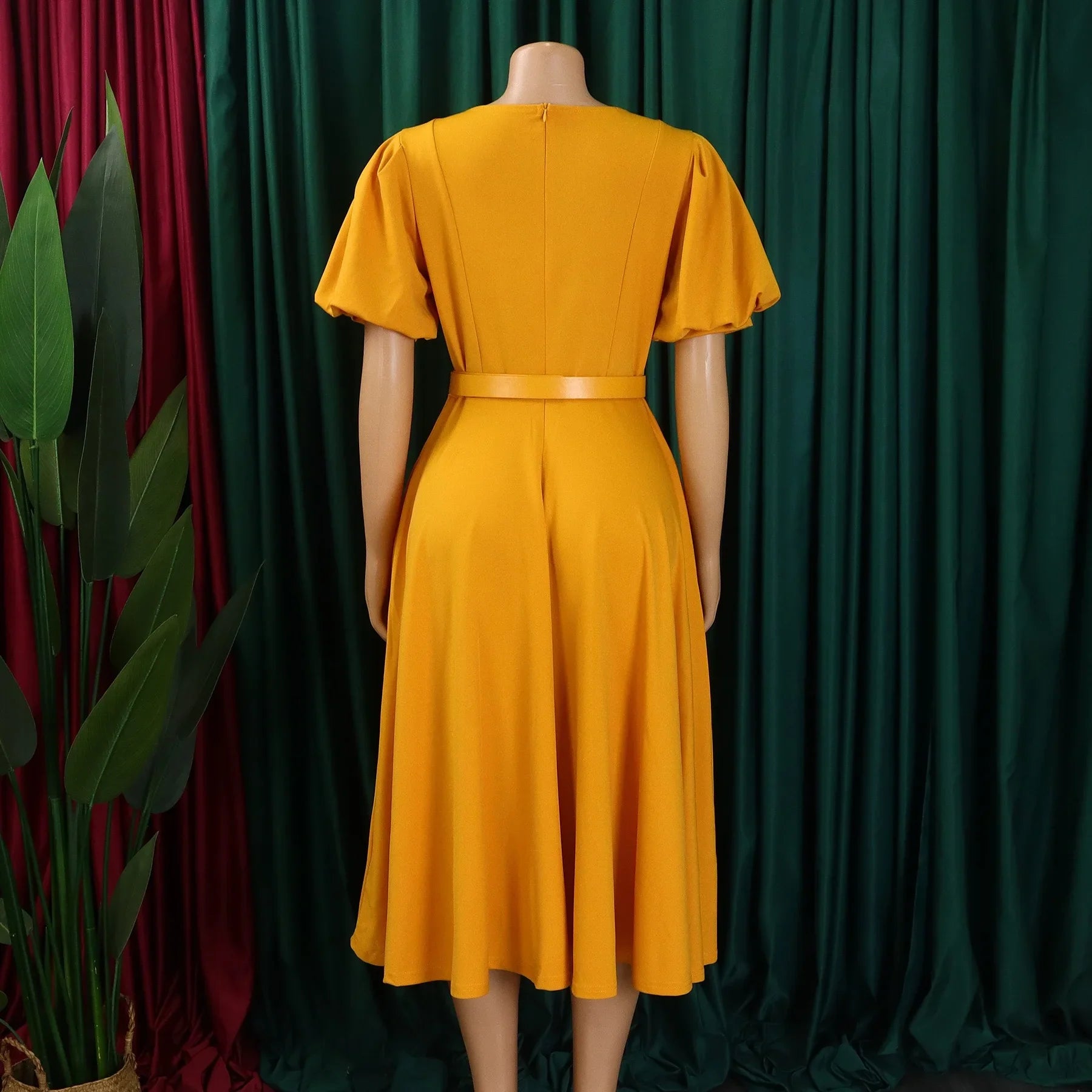 A mustard yellow midi dress with short sleeves, a round neckline, and a matching waist belt.