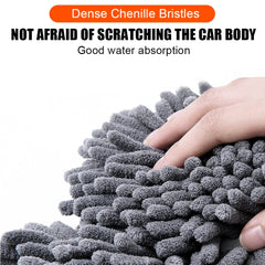 A hand touches a soft, grey chenille car wash mop head with dense, absorbent bristles.