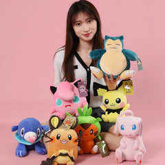 A young woman holds a Snorlax plush surrounded by various colorful Pokemon stuffed toys.