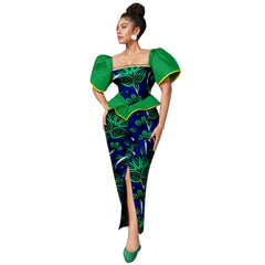 A woman wears an ankle-length Ankara print dress with a square neckline and green puff sleeves.