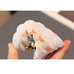 A hand holds a flexible, breathable toddler sneaker with a thick, translucent rubber sole.