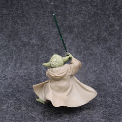 A Master Yoda action figure holding a green lightsaber, viewed from behind on a grey background.