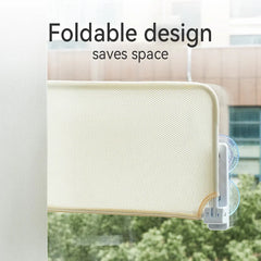 A beige mesh cat window perch attached to a glass window with suction cups.